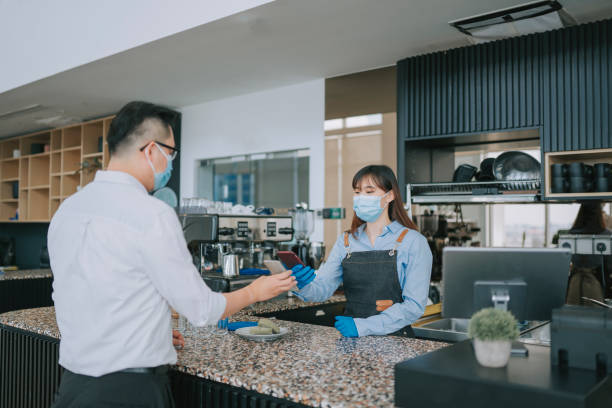 istock An asian chinese cafe waitress receiving payment from her customer at counter using QR code contactless paymen 1306131074