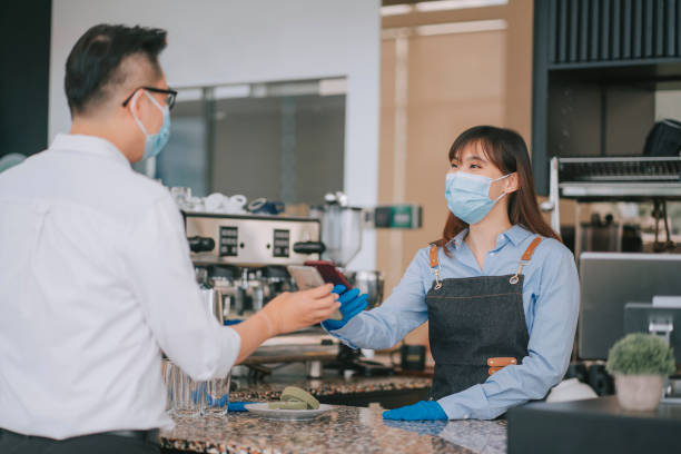 istock An asian chinese cafe waitress receiving payment from her customer at counter using QR code contactless paymen 1306131088