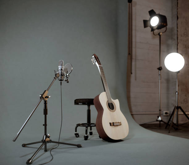 istock Acoustic guitar and microphone in recording studio with spotlight on background.3d rendering 1306132568