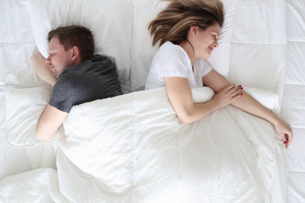 jeune homme et femme se trouvant sous la vue supérieure de couvertures - sleeping lying on back couple bed photos et images de collection