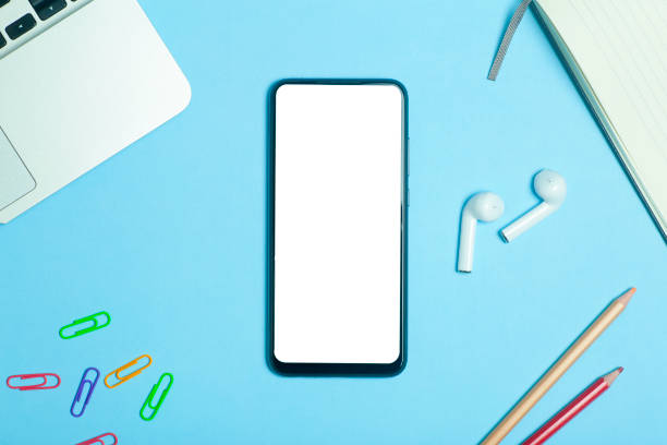 istock Smartphone blank screen on a work table place background with headphones. 1306137806