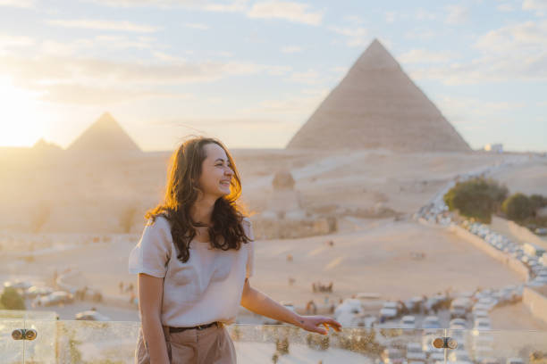mujer de pie en la terraza sobre el fondo de las pirámides de guiza - tourist egypt pyramid pyramid shape fotografías e imágenes de stock