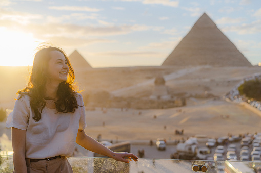 Woman standing on the  terrace on the  background of Giza pyramids