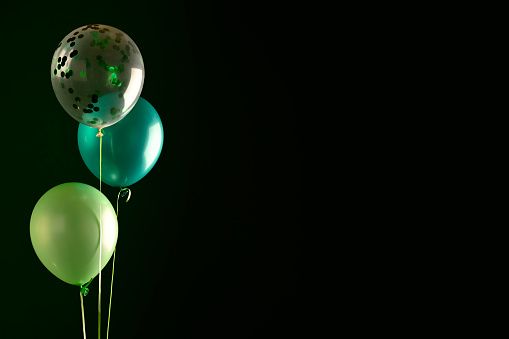 Concept of St. Patrick. Green balloons on dark background, copy space for text