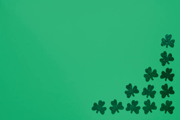 istock Green clovers on green background 1306143589