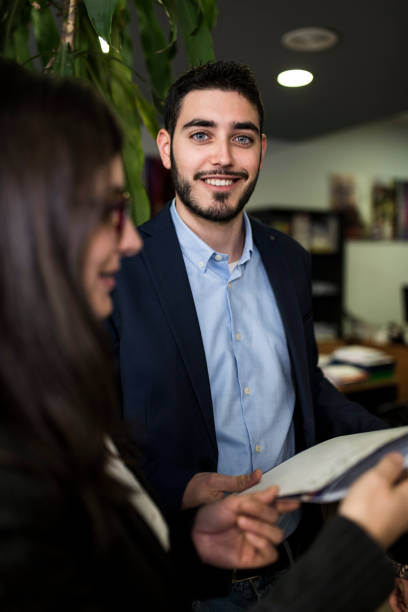 istock Man in office smiling looking at camera at workplace in bank 1306143714