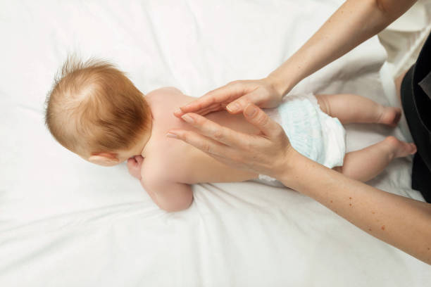 young mother doing massage on baby back. body health problem. baby massage concept. infant baby 3 month old lying on tummy - 3675 imagens e fotografias de stock
