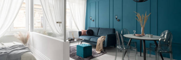 istock Living room with teal blue wall, panorama 1306144515