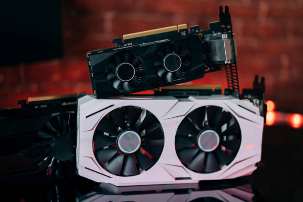 istock Graphics cards of different sizes and configurations on black table under neon light. Part of computer for gaming and cryptocurrency mining 1306144547