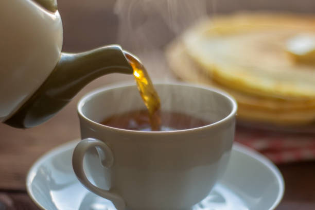 istock Tea is poured into a breakfast cup with pancakes. 1306145609