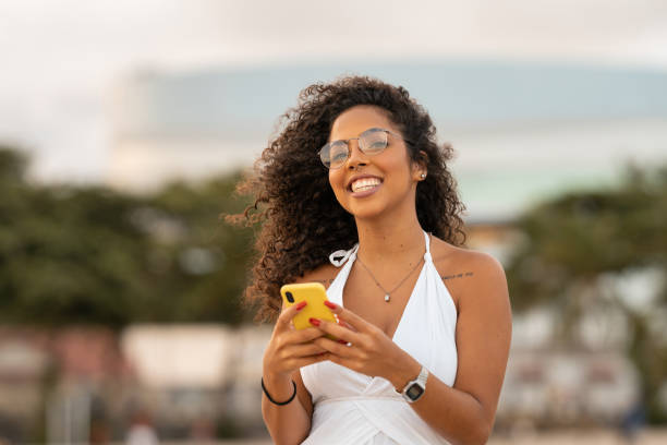 istock Happy woman using smart phone on the beach 1306153052