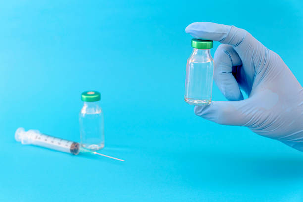 istock Potential trials stage concept on blue background. Close up Vials with sterile needle syringe. Research and Development, Vaccination 1306153722