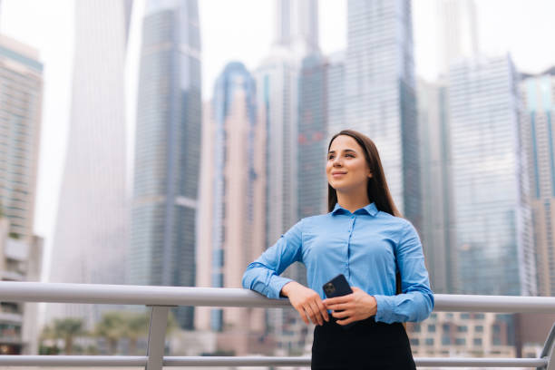 istock Business woman use mobile phone on skyscrapers backgound 1306153886