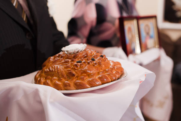 wedding loaf in a white towel is held in his hands. Wedding
