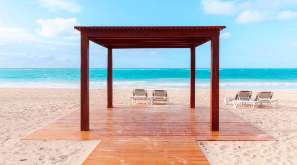 An empty wooden gazebo and sun loungers