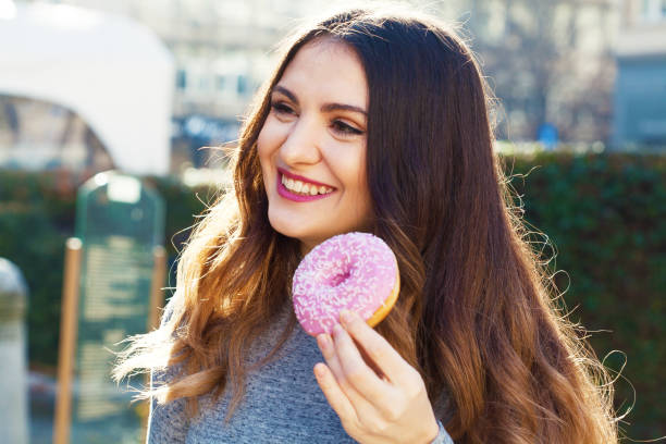 istock Young woman eating a donut 1306160489