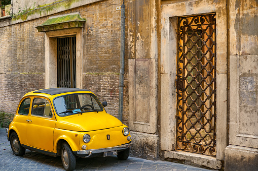 A vintage Fiat 500 parked along an alley in the Piazza di Spagna district in the heart of Rome