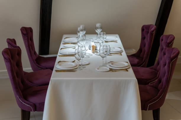 istock Chic and elegant, gold-plated cutlery and white plates, table setting with empty plates. Beautiful armchairs and a fully covered table. 1306168179