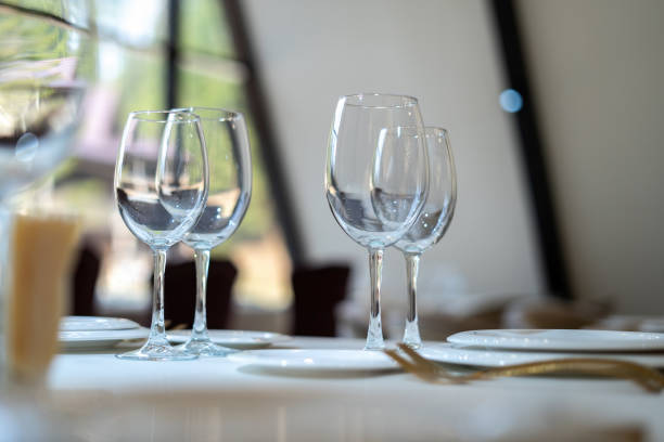 istock Chic and elegant, gold-plated cutlery and white plates, table setting with empty plates. Glasses in the light from the window. Side view. 1306168209