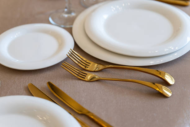 istock Chic and elegant, gold-plated cutlery and white plates, table setting with empty plates. Clouse-up. 1306168221