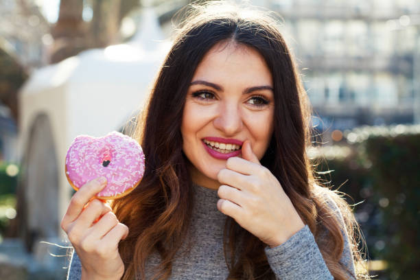 istock Young woman eating a donut 1306171773