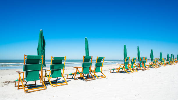 Fort Myers Beach Lounge chairs and umbrellas along popular Fort Myers Beach on the west coast of Florida. fort myers photos stock pictures, royalty-free photos & images