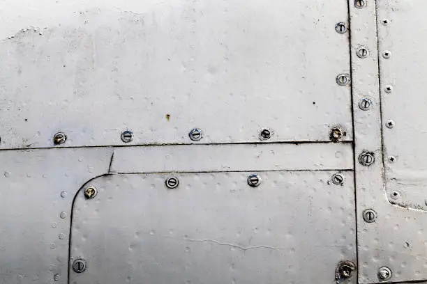 aluminum sheets joined together by welding and riveting, close-up of part of the outer skin of the fuselage of the aircraft