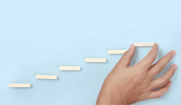 istock Block stacking as step stair in hand. Business concept 1306179399