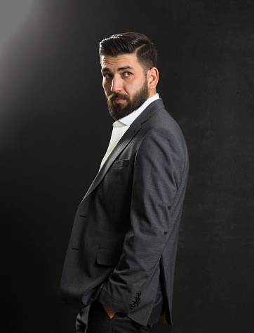 Portrait of a young businessman in suit, studio shot, Black background