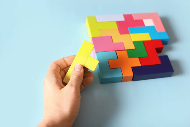 istock Multicolored puzzle, hand and cubes on a blue background 1306181640