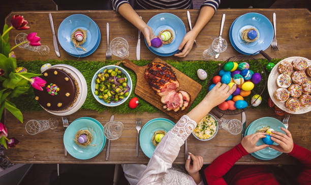 Easter Table Overhead view on decorated Easter table with family around april 10 stock pictures, royalty-free photos & images