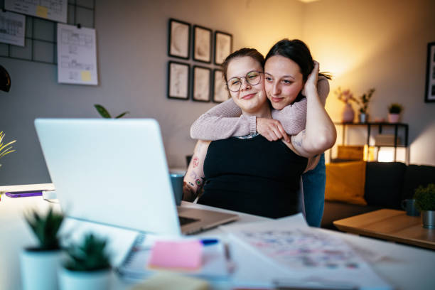 istock Cheerful lesbian couple working from home and surfing the net 1306183934