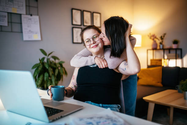 Lesbian couple working from home and sharing love with smiles
