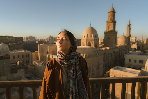 Portrait of woman in hijab looking at Cairo from the rooftop