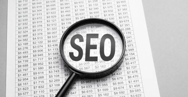 istock Finance and economics concept. Magnifier on a white background, inside the text is written - SEO 1306186381
