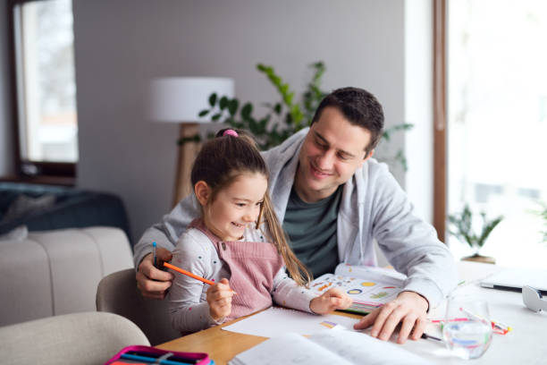 istock Father helping daugther with homework indoors at home, distance learning. 1306186606
