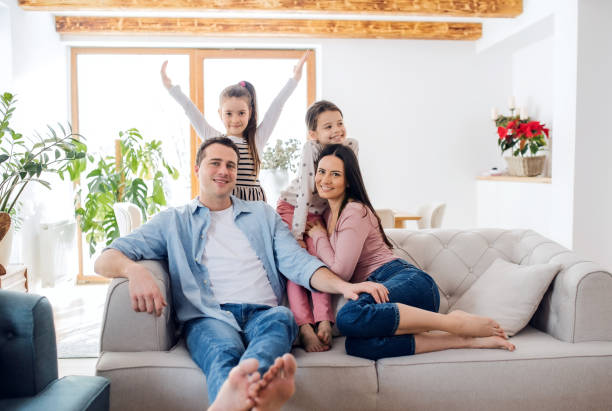 istock Parents with small daughters sitting on sofa indoors at home, relaxing. 1306186694
