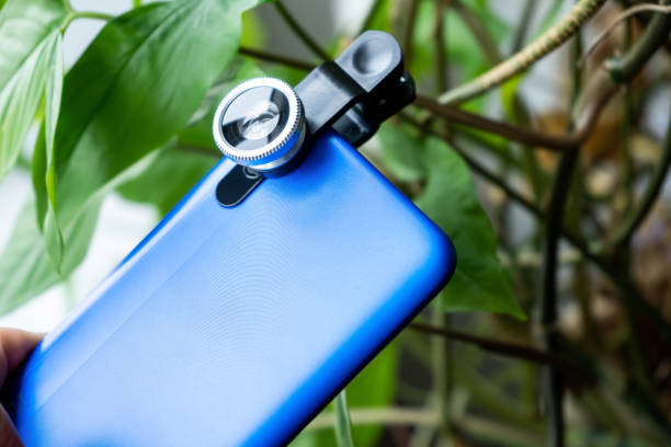 Overhead phone lens with clips on the blue modern smartphone. Extra macro camera for mobile device