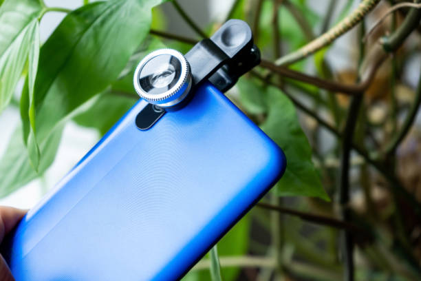 Overhead phone lens with clips on the blue modern smartphone. Extra macro camera for mobile device stock photo
