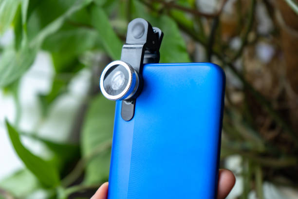 istock Overhead phone lens with clips on the blue modern smartphone. Extra macro camera for mobile device 1306186753