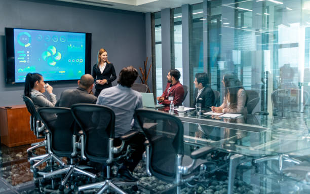 istock Businesswoman presenting in boardroom 1306186875