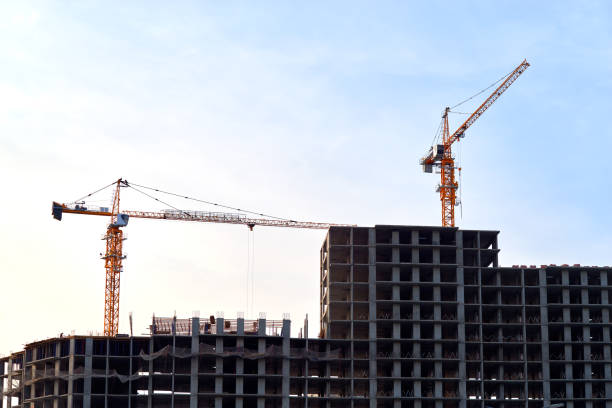 istock Construction site with new buildings and cranes at dusk evening yellow cloudy sky background, sunlight, back light 1306186986