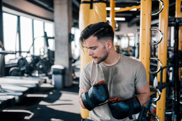 istock Young man with boxing gloves on a break from workout at the gym. 1306189793