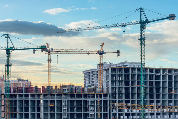 istock Construction site, cranes and multi-storey unfinished buildings at sunrise or sunset 1306190903