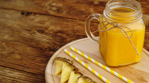 istock Bottles of pineapple juice on a wooden table. 1306190969