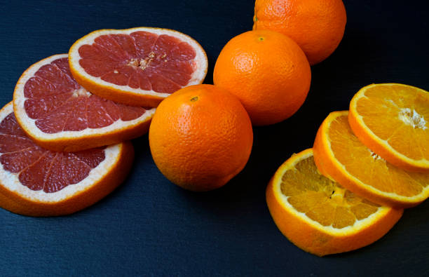 istock Citrus fruit sliced and arranged on black serving platter 1306191780