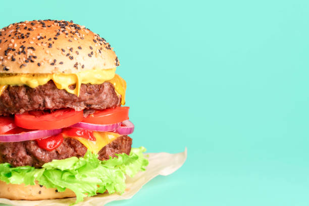 istock Hamburger side view close-up isolated on a green background. 1306192094