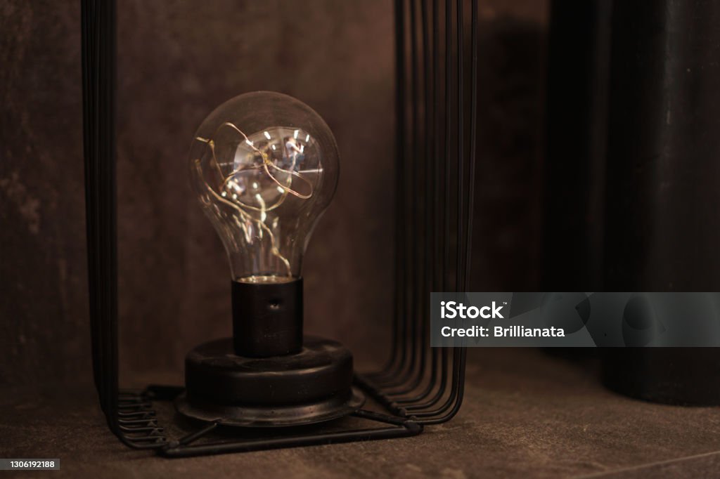 Edison lighbulb on a stand. One old decorative lamp for loft Edison lighbulb on a stand. One old decorative lamp for loft and industrial interiors Art Stock Photo