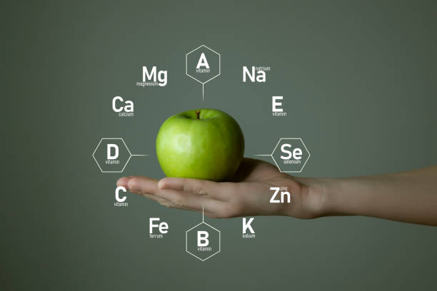 istock Woman`s hand holding green apple, microelement icons in molecular hexagons on grey background. 1306192272