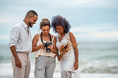 Photographer shows wedding photos to the bride and groom